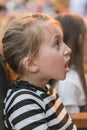 little girl sitting on armchairs at cinema or in the theater. The girl with great interest in the theater. Beautiful little girl Royalty Free Stock Photo