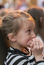 little girl sitting on armchairs at cinema or in the theater. The girl with great interest in the theater. Beautiful little girl Royalty Free Stock Photo