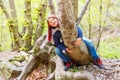 Little girl sitting astride a log in a forest