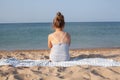 Little girl sitting back on the beach and enjoying summer sea and sun Royalty Free Stock Photo