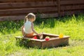 Little girl sitting back playing in sandbox Royalty Free Stock Photo