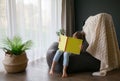 Little girl sitting on a bean bag and reading book Royalty Free Stock Photo