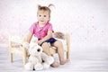 Little girl sitting on the bed holding plush toy Royalty Free Stock Photo