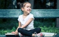 Little girl is sitting on a bench and is reading a book Royalty Free Stock Photo