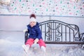 Little girl sitting on a bench in the skating rink Royalty Free Stock Photo