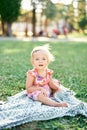 Little girl sitting on a blanket in the park Royalty Free Stock Photo