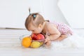 A little girl is sitting in a bright room with a plate of fruit and eating an Apple Royalty Free Stock Photo