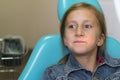 Little girl sitting in a chair near a dentist after dental treatment. Little girl sitts in the dentist`s office Royalty Free Stock Photo