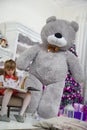 Little Girl sitting on a chair and reading a book, gave her at Christmas. Royalty Free Stock Photo