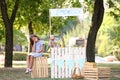 Little girl sitting on crate near lemonade stand in park Royalty Free Stock Photo