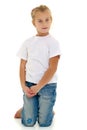 A little girl is sitting on the floor in a clean white T-shirt. Royalty Free Stock Photo