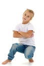 A little girl is sitting on the floor in a clean white T-shirt. Royalty Free Stock Photo