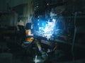 Little girl sitting in front of blue screen monitor as technical routine in computer and phone repair shop service with messy offi