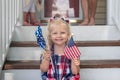 Little girl sitting on front steps on Fourth of July Royalty Free Stock Photo