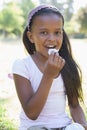 Little girl sitting on grass eating Royalty Free Stock Photo