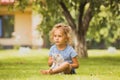 The little girl is sitting on the grass and holding a kitten Royalty Free Stock Photo