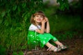 Little girl sitting on green grass Royalty Free Stock Photo