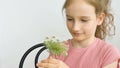 Little girl is sitting at home with flowers in hands during summer time and sneezing, hypersensitivity, asthma, or