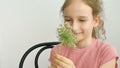 Little girl is sitting at home with flowers in hands during summer time and sneezing, hypersensitivity, asthma, or