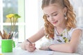 Little girl sitting at kitchen table and drawing Royalty Free Stock Photo