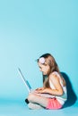 Little girl sitting with laptop on her knees, looking at the screen. Royalty Free Stock Photo