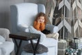 Little girl sitting in the living room near a stylized Christmas tree. Royalty Free Stock Photo