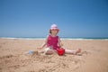 Little girl sitting making a castle in sand beach Royalty Free Stock Photo