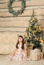 Little girl sitting near Christmas tree Royalty Free Stock Photo