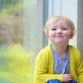 Little girl sitting next window on rainy day Royalty Free Stock Photo