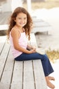 Little girl sitting outdoors holding starfish Royalty Free Stock Photo