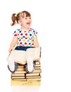 Little girl sitting on a pile of books isolated Royalty Free Stock Photo