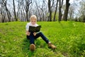 Little girl sitting and reading a book on nature Royalty Free Stock Photo