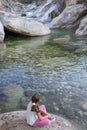 Little girl sitting at riverside of Los Pilones Gorge at Natural Reserve Garganta de los Infiernos
