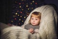 Little girl sitting on rocking chair near the christmas tree Royalty Free Stock Photo