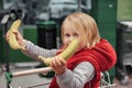 Little girl sitting in shopping cart in food fruit store or supermarket Royalty Free Stock Photo