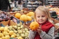 Little girl sitting in shopping cart in food fruit store or supermarket Royalty Free Stock Photo