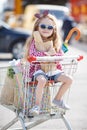 Little girl sitting in shopping trolley Royalty Free Stock Photo