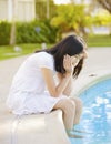 Little girl sitting by side of pool, sad Royalty Free Stock Photo