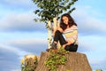 Little girl sitting on stump by new linden Royalty Free Stock Photo
