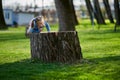 Little girl sitting on a stump in the park Royalty Free Stock Photo