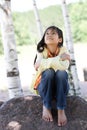 Little girl sitting under trees