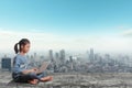 Little girl sitting using laptop computer on modern city skyline Royalty Free Stock Photo