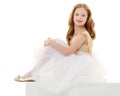 The little girl is sitting on a white banner. Royalty Free Stock Photo