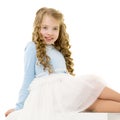 The little girl is sitting on a white banner. Royalty Free Stock Photo