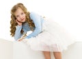 The little girl is sitting on a white banner. Royalty Free Stock Photo