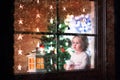 Little girl sitting at a window on Christmas eve Royalty Free Stock Photo