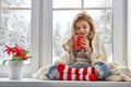 Little girl sitting by the window Royalty Free Stock Photo