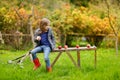 Little girl sitting on a wooden bench on autumn Royalty Free Stock Photo