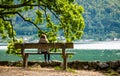 Little girl sitting on the bench and looking on the river scenery Royalty Free Stock Photo