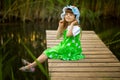 Little girl sitting on wooden bridge across river Royalty Free Stock Photo